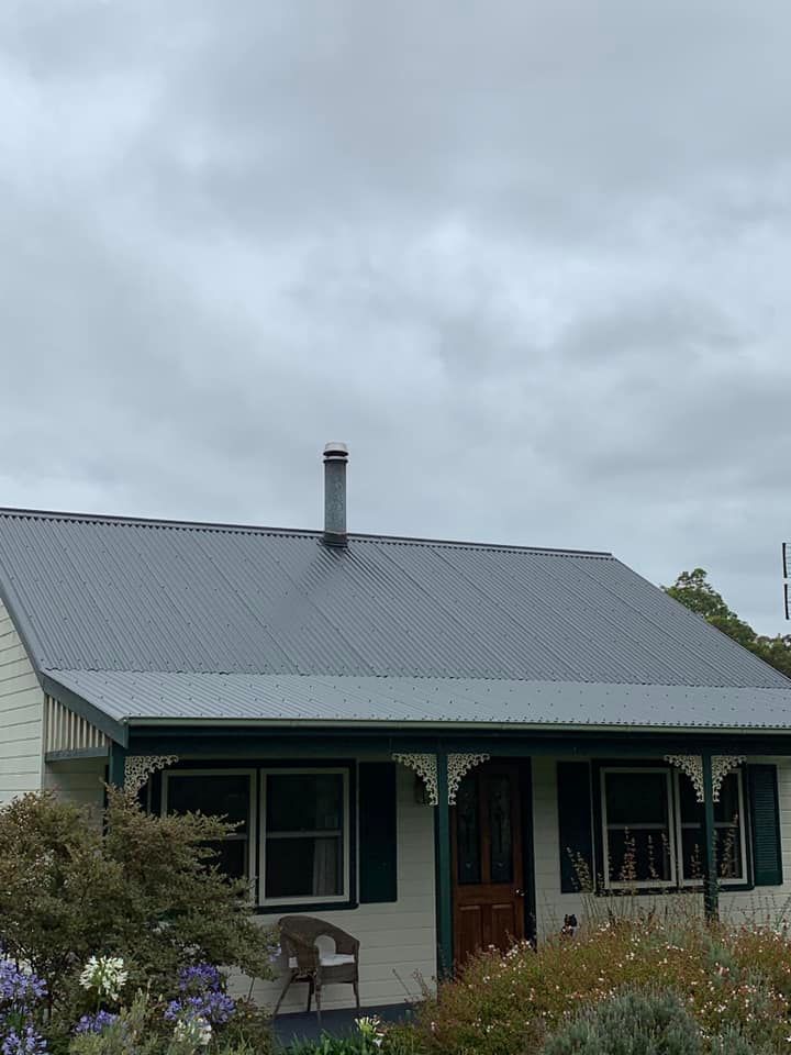Heritage cottage with new grey corrugated metal under Tassie sky