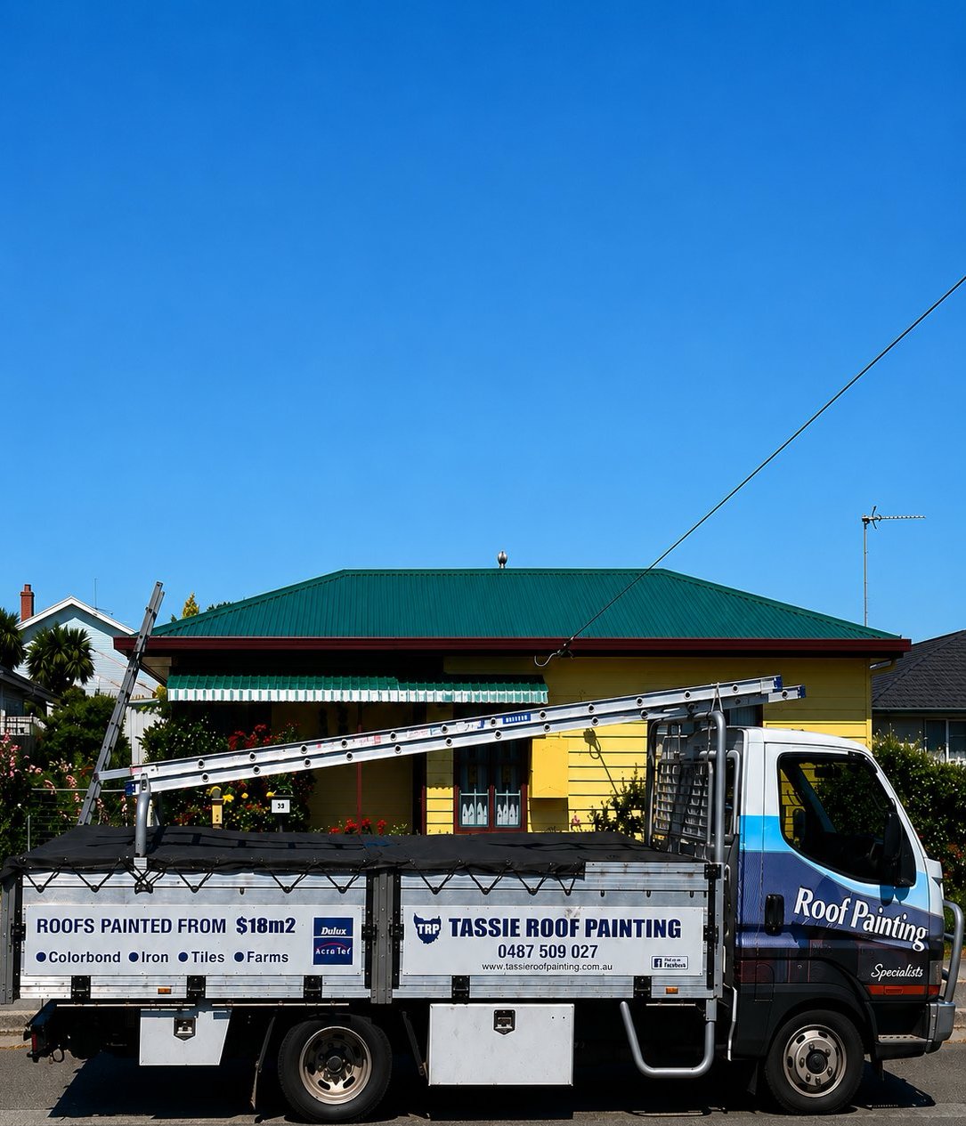Tassie Roof Painting truck parked on a Tassie street with a green-roofed yellow weatherboard house behind. Side panel reads ROOFS PAINTED FROM $18m². Colorbond, iron, tiles, farms.