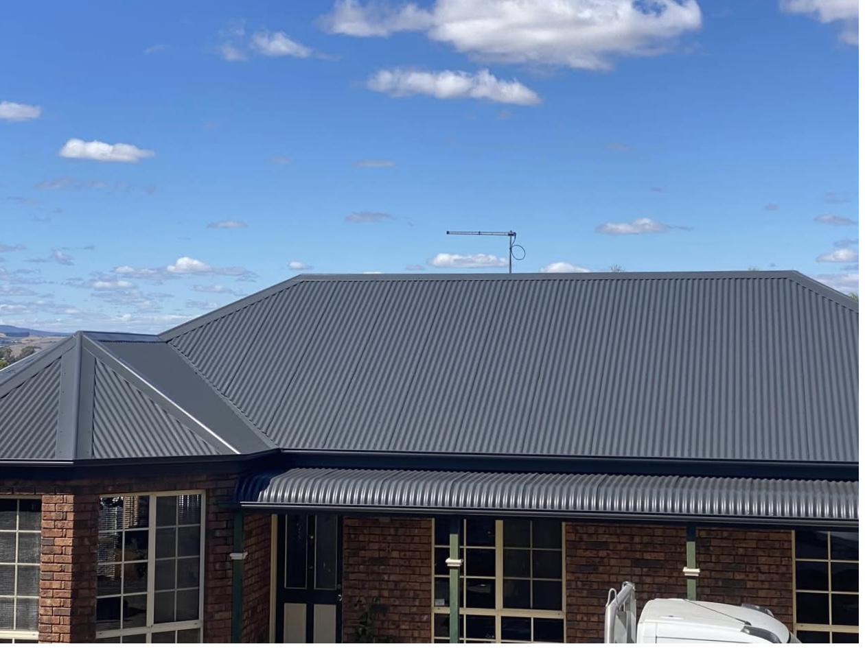 Same Tasmanian home with crisp charcoal Colorbond Monument finish on the corrugated metal roof