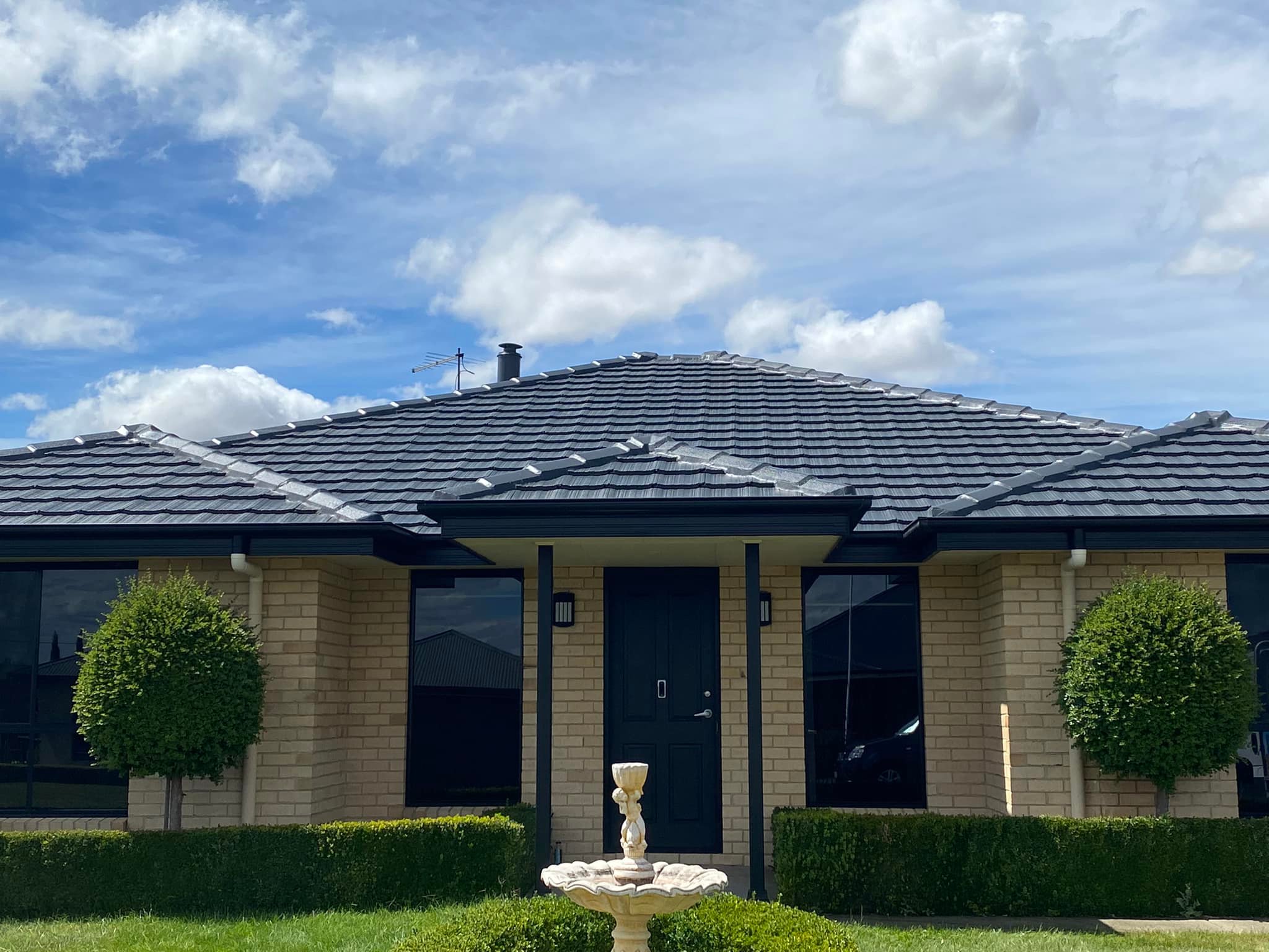 Red brick suburban home with new charcoal metal roof