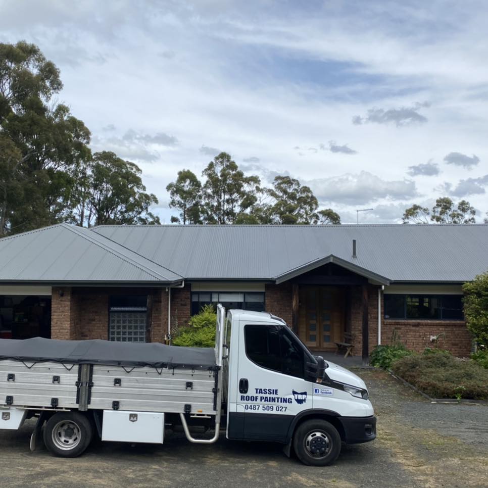 Brick home with new mid-grey metal roof, gum trees behind